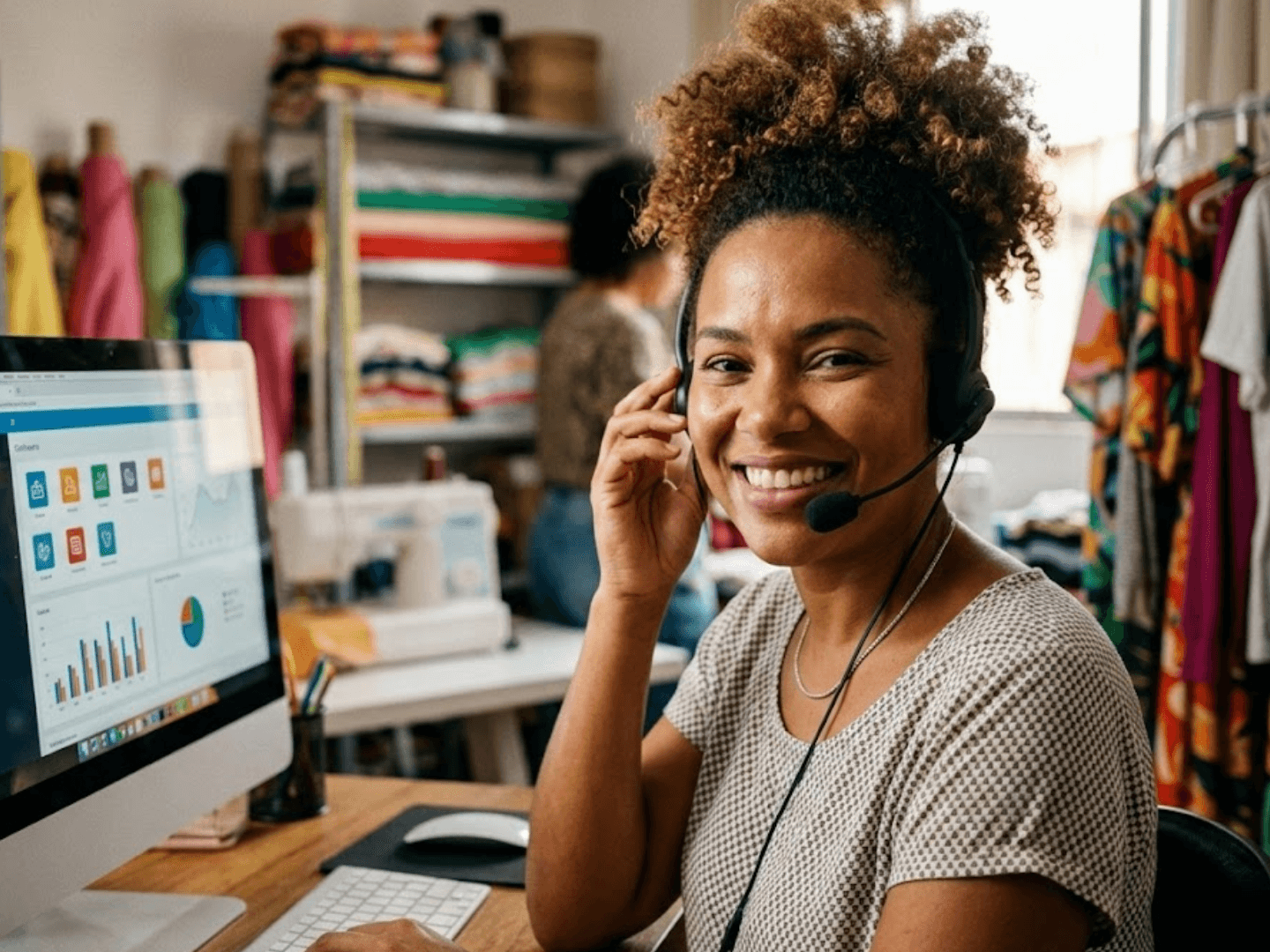 Empreendedora com headset atendendo clientes com sistema de IA e dashboard no computador